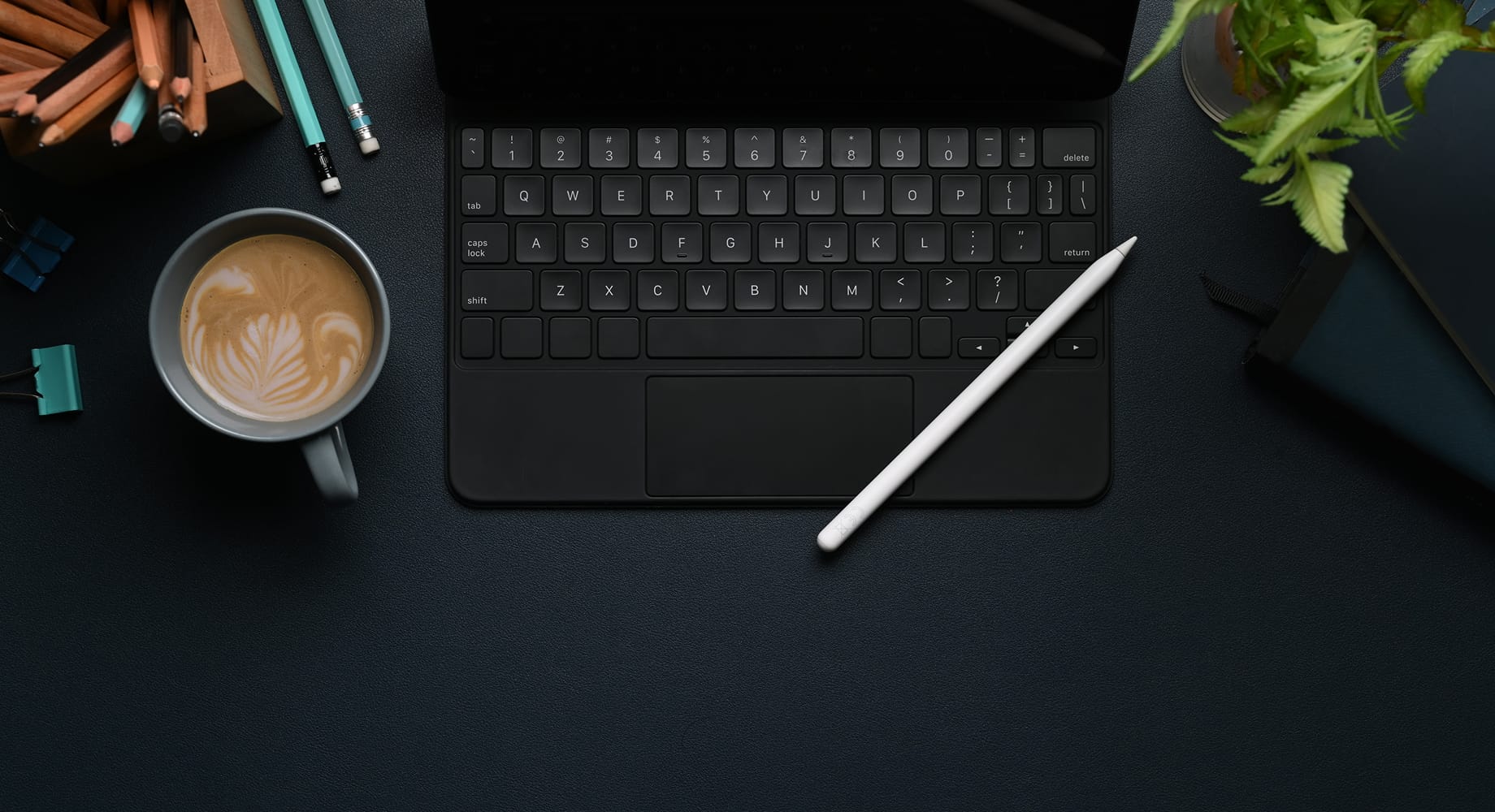 Coffee next to an iPad keyboard in a dark setting